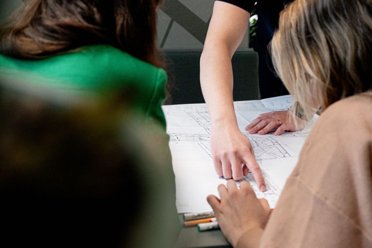 Man die iets aanwijst op een plattegrond