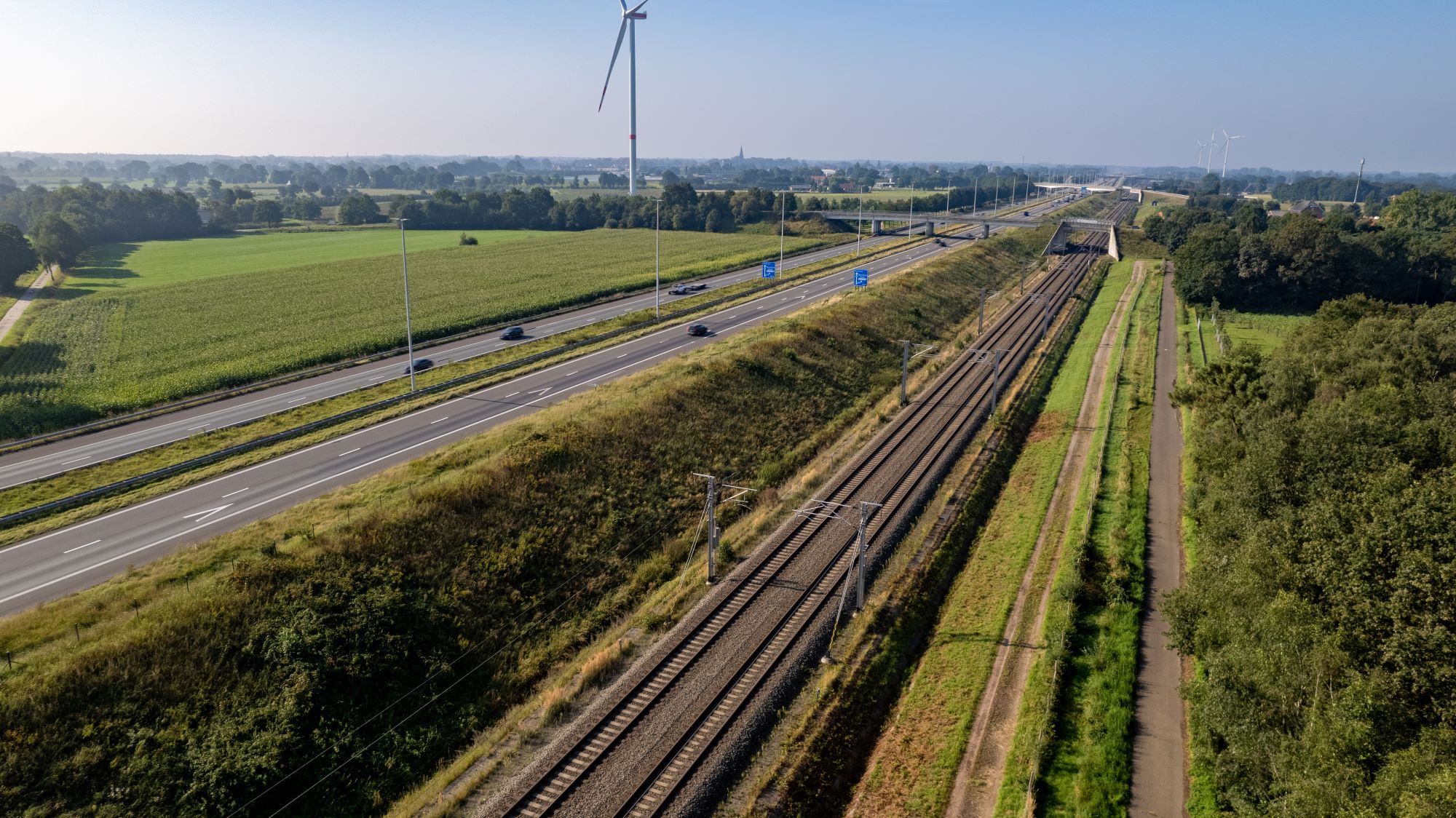 Luchtfoto van spoor met snelweg die daar parallel aan loopt.